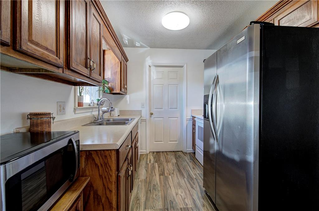 302 Douglas Street Cartersville, GA 30120 - Photo 12 of 29 a kitchen with stainless steel appliances granite countertop a refrigerator a stove and a sink with wooden floor