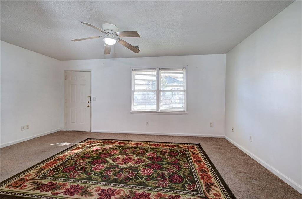 302 Douglas Street Cartersville, GA 30120 - Photo 6 of 29 an empty room with wooden floor a rug and a window