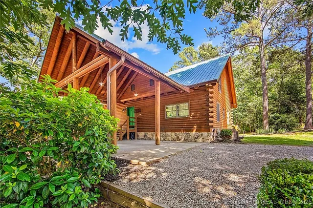 a view of a house with backyard and trees