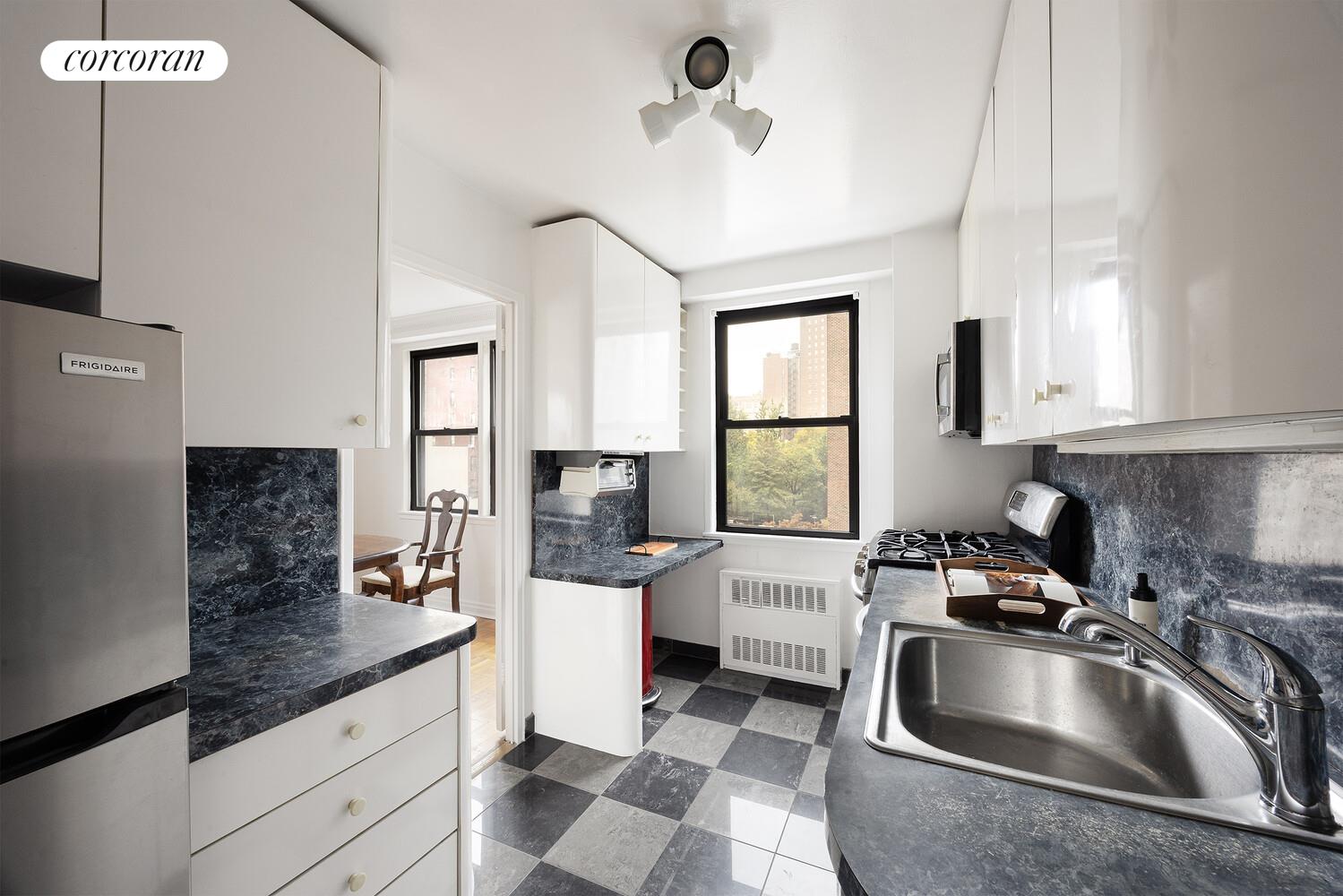 201 East 21st Street, Unit 7S Manhattan, NY 10010 - Photo 5 of 12 a kitchen with a sink stove and microwave