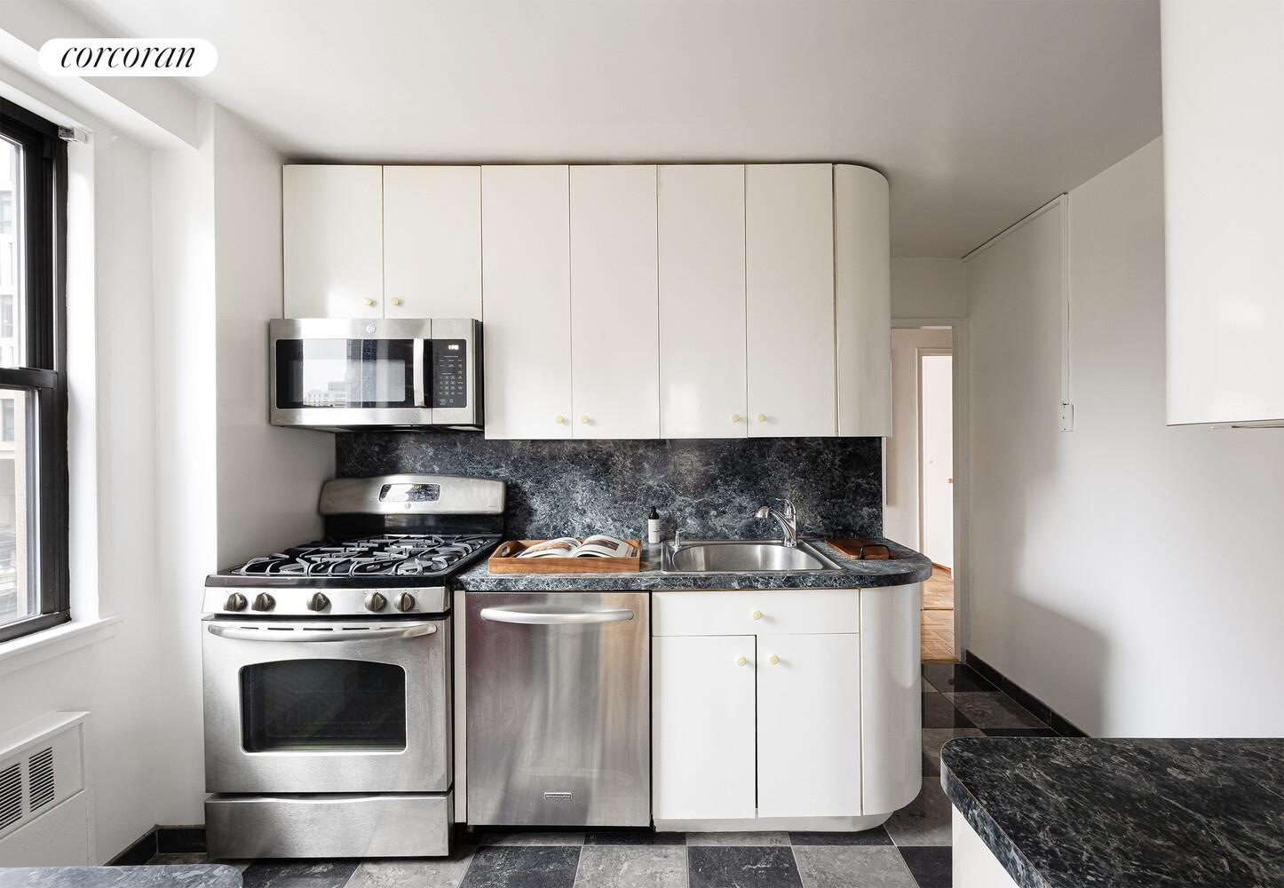 201 East 21st Street, Unit 7S Manhattan, NY 10010 - Photo 6 of 12 a kitchen with stainless steel appliances a stove a microwave and cabinets
