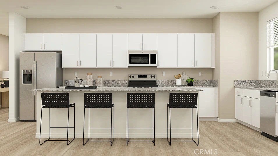 24812 Sirius Avenue Moreno Valley, CA 92551 - Photo 1 of 16 a kitchen with stainless steel appliances a stove a sink cabinets and a refrigerator
