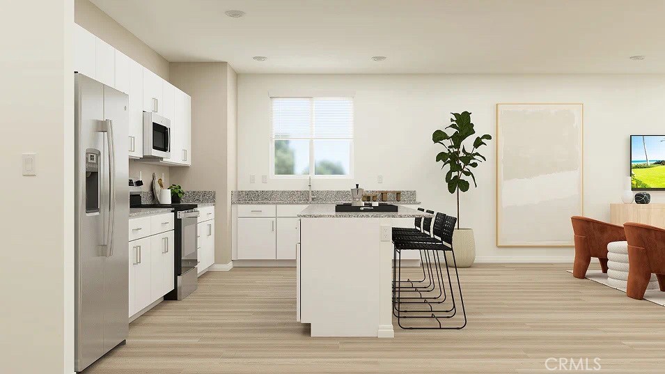 24812 Sirius Avenue Moreno Valley, CA 92551 - Photo 2 of 16 a kitchen with a refrigerator and a stove top oven