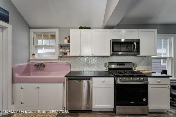 a kitchen with stainless steel appliances a sink cabinets and a refrigerator