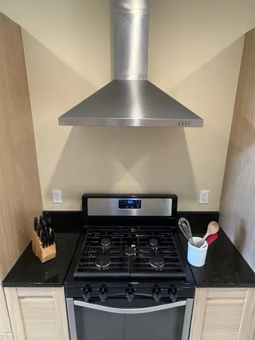 a kitchen with stainless steel appliances granite countertop a sink a microwave a refrigerator and a stove