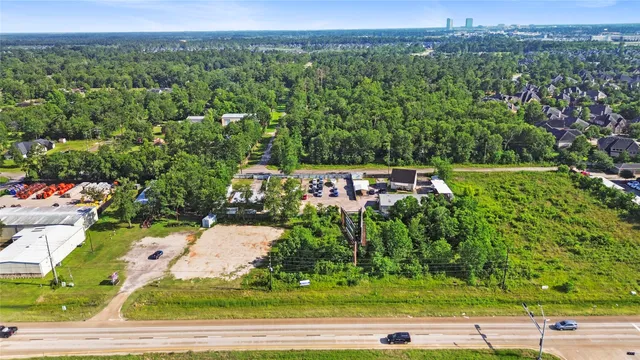 an aerial view of residential houses with outdoor space and trees