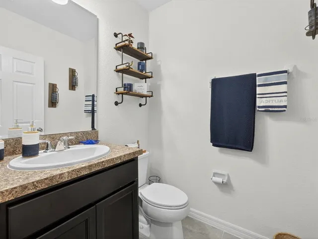 a bathroom with a granite countertop toilet sink and mirror