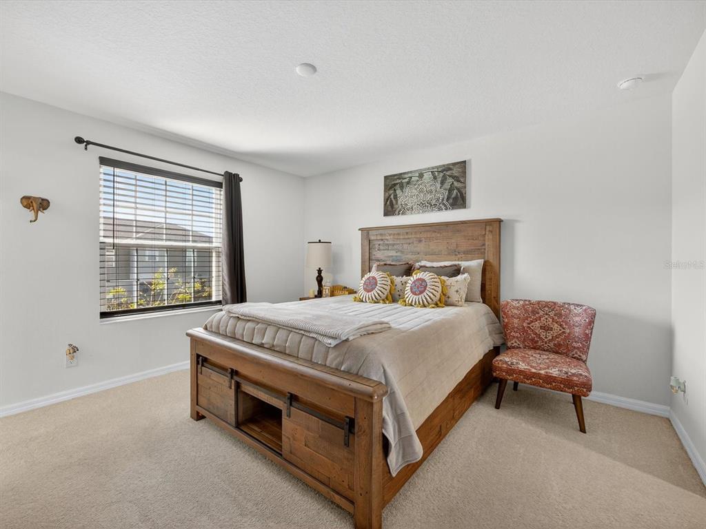 439 Annabelle Way Davenport, FL 33837 - Photo 14 of 31 a bed sitting in a bedroom next to a window