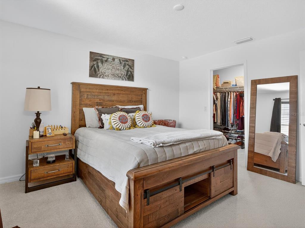 439 Annabelle Way Davenport, FL 33837 - Photo 15 of 31 a bedroom with a bed and a chandelier