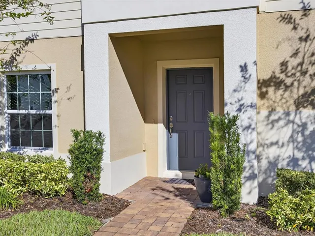 front view of a house with a potted plant and plants