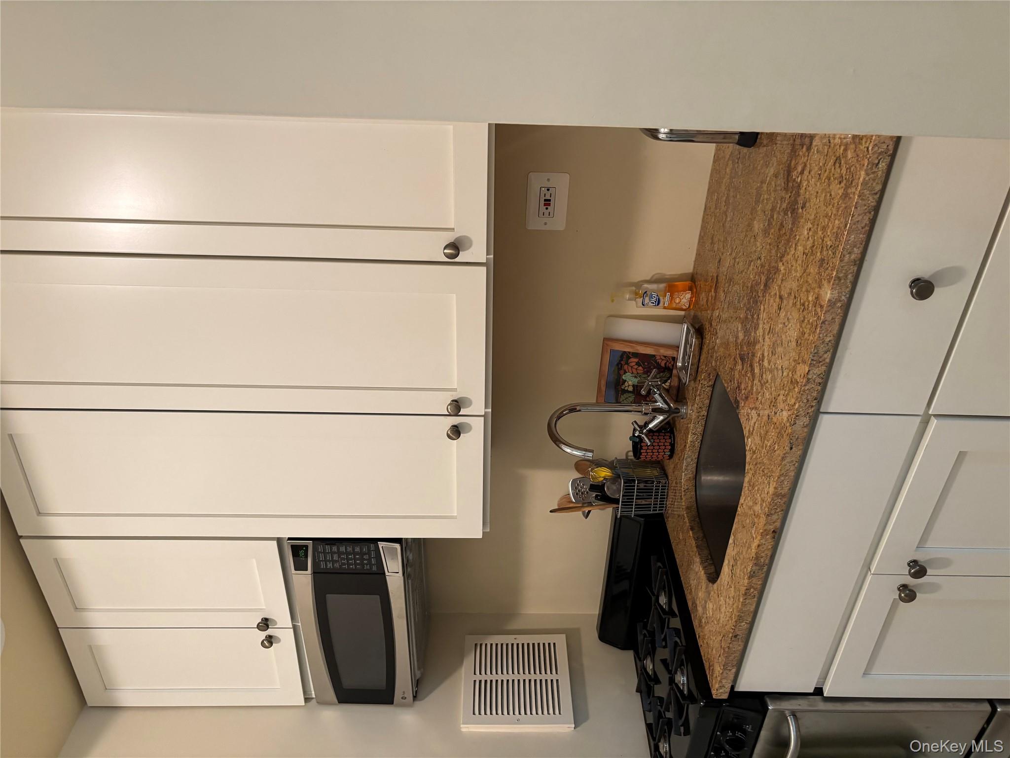 430 East 85th Street, Unit 6B Manhattan, NY 10028 - Photo 4 of 9 a kitchen with stainless steel appliances granite countertop white cabinets and a sink