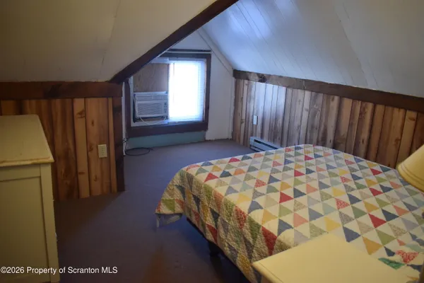 a bed sitting in a spacious bedroom next to a window
