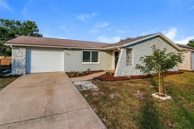 a view of a house with a yard and potted plants