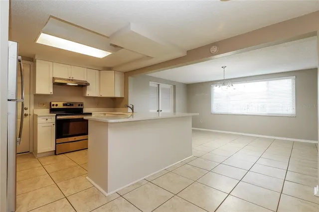 a kitchen with granite countertop a stove a sink and a refrigerator