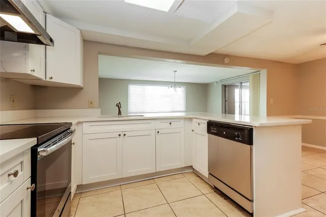 a kitchen with granite countertop white cabinets and white appliances