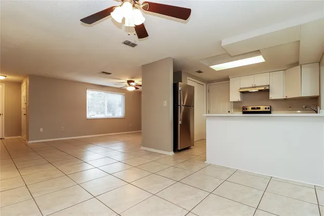 a view of kitchen with stainless steel appliances cabinets and refrigerator