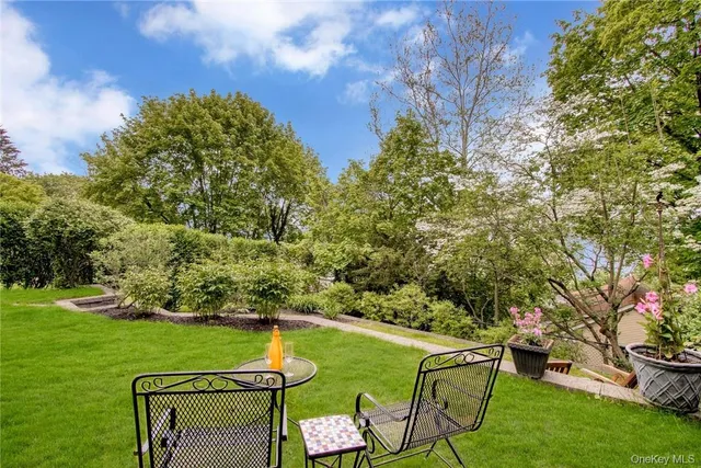 a view of a wooden chairs and table in the garden