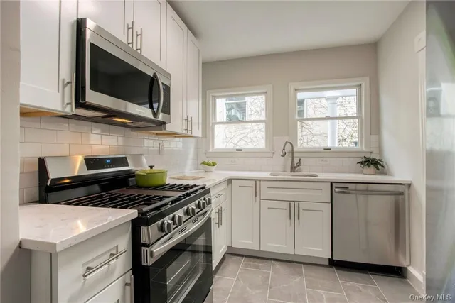 a kitchen with stainless steel appliances a sink dishwasher stove microwave and cabinets