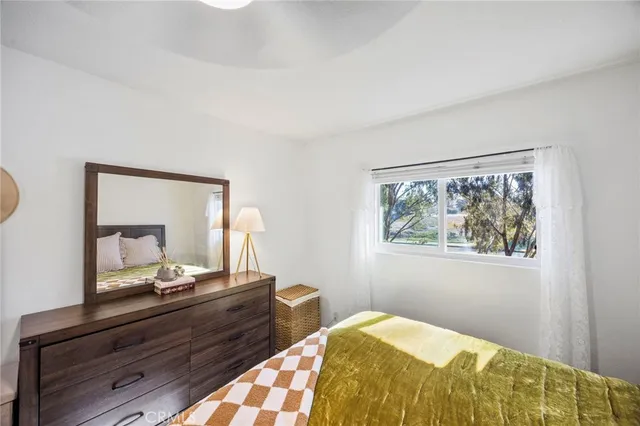 a bedroom with a bed and a mirror on dresser