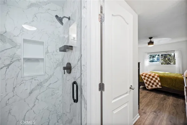a bathroom with a tub shower and a mirror