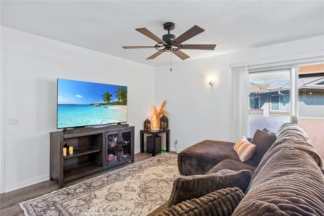 a living room with furniture a ceiling fan and a rug