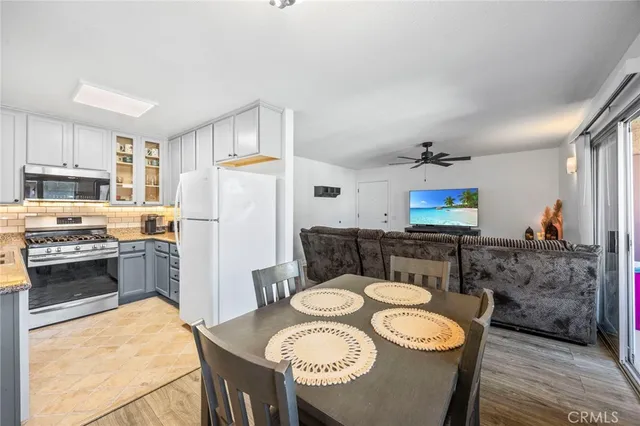 a kitchen with stainless steel appliances granite countertop a sink a stove a refrigerator a stove a dining table and chairs