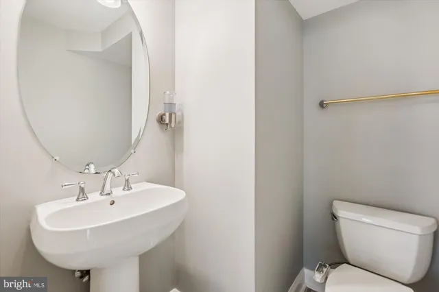 a bathroom with a sink toilet and a mirror