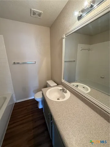 a bathroom with a sink a toilet and a mirror