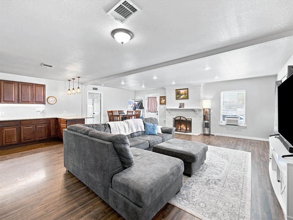408 Inwood Road Azle, TX 76020 - Photo 5 of 32 Open-concept living area with wood-finish flooring, a fireplace, recessed lighting, and a dining area