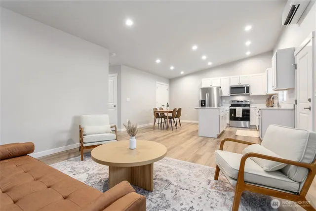 a living room with furniture and a dining table with kitchen view