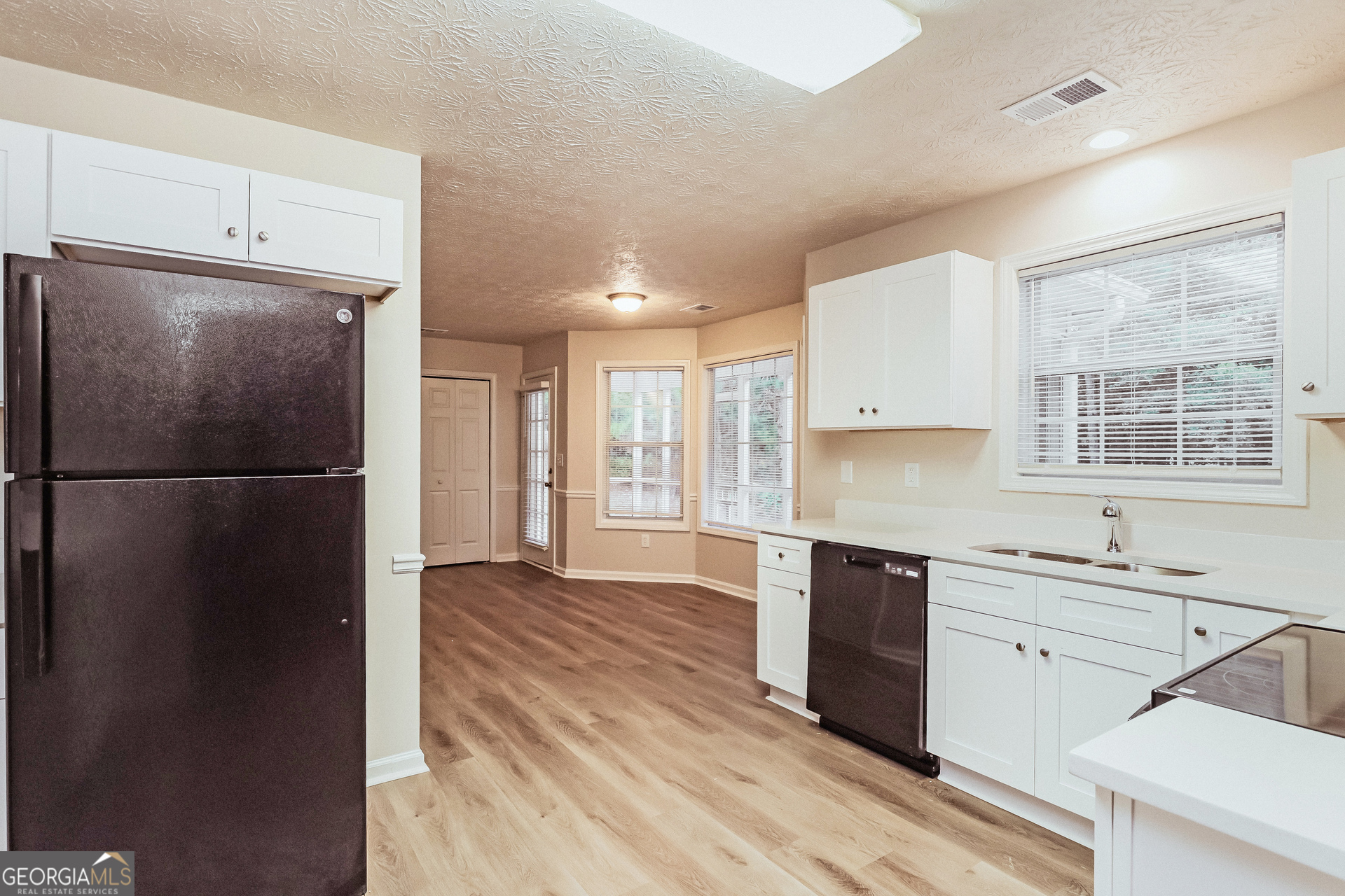 35 Spring Valley Keep Covington, GA 30016 - Photo 7 of 16 a kitchen with a refrigerator a sink and dishwasher with wooden floor