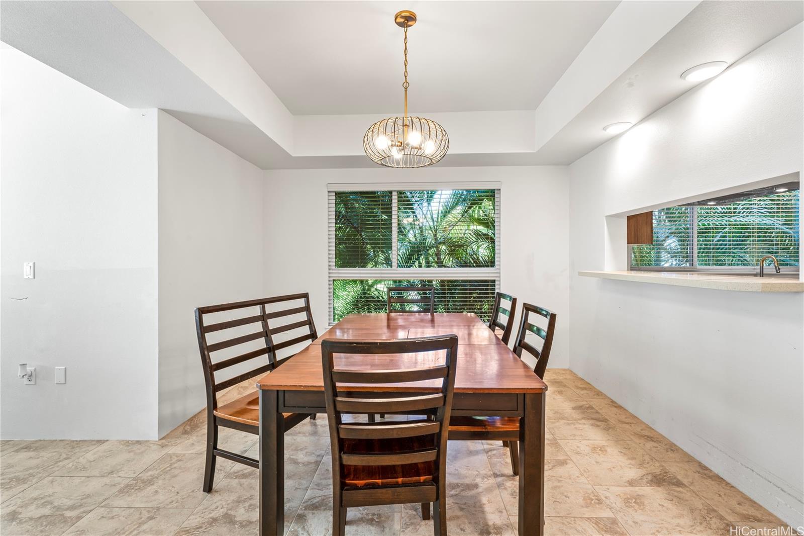 437 Kailua Road, Unit 6102 Kailua, HI 96734 - Photo 13 of 22 a view of a dining room with furniture a chandelier and wooden floor