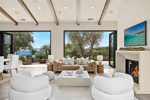 a living room with fireplace furniture large window and a flat screen tv