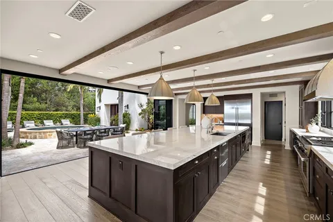 a large kitchen with kitchen island a large window a sink and counter space