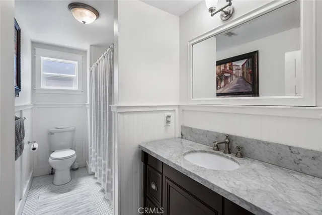 a bathroom with a granite countertop sink mirror vanity and toilet