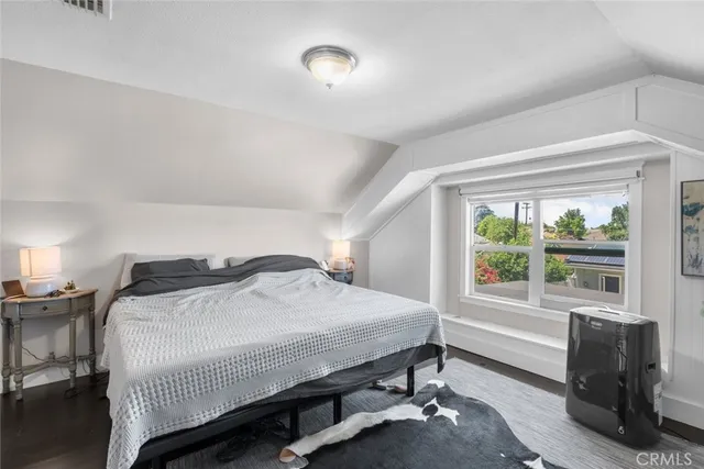 a bedroom with a bed and a large window