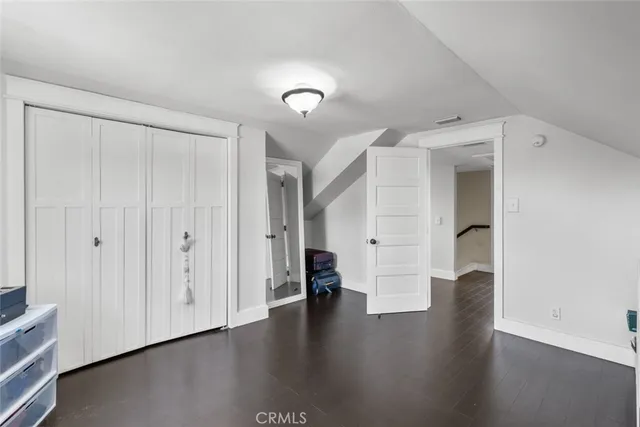 a view of an empty room with wooden floor and windows