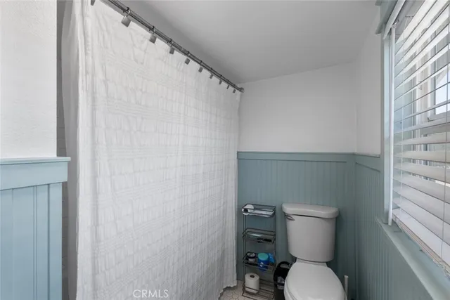a white toilet sitting next to a shower curtain
