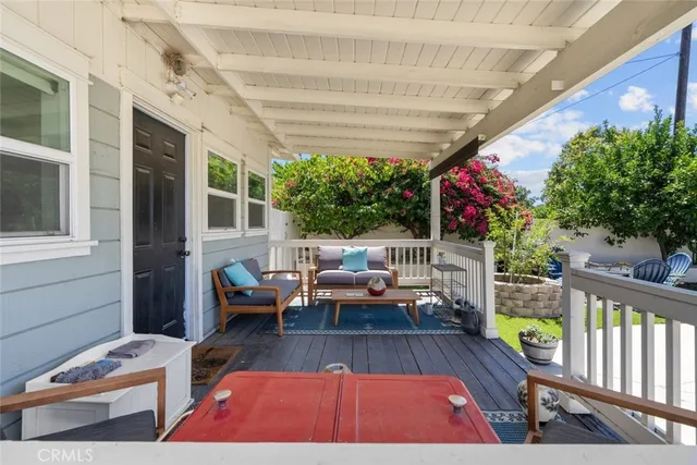 a living room with patio furniture and a potted plant