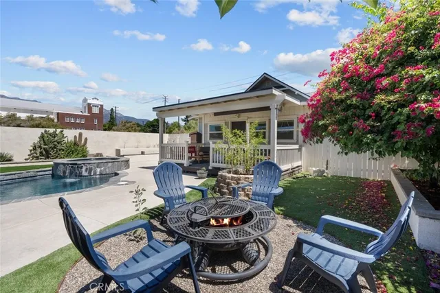 a backyard of a house with dining table and chairs with plants