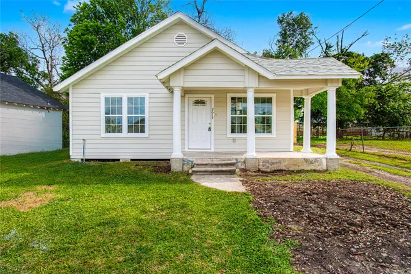 a view of a house with backyard and sitting area