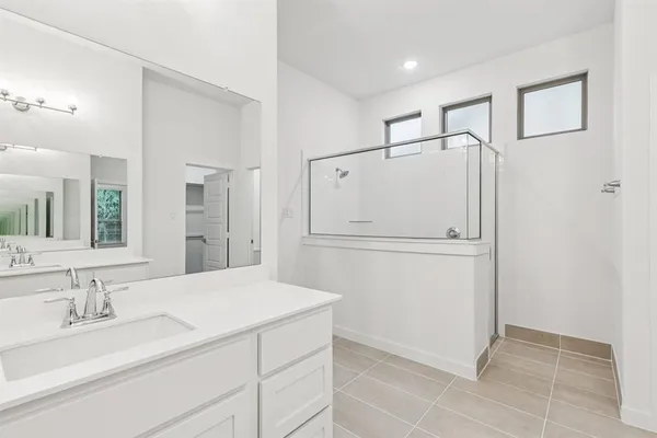 a bathroom with a shower sink and mirror