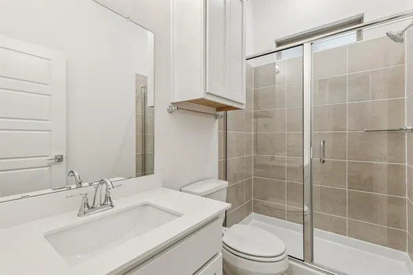 a bathroom with a sink a toilet and shower