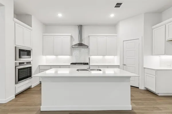 a kitchen with kitchen island white cabinets and stainless steel appliances