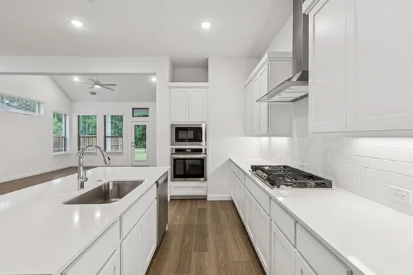 a kitchen with granite countertop a sink stove and cabinets