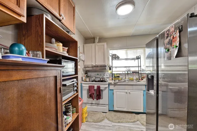 a kitchen with stainless steel appliances granite countertop a refrigerator and a stove