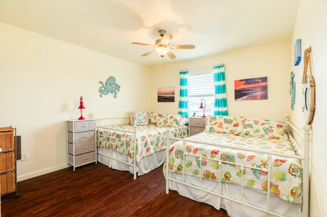 a bedroom that has two beds and a chandelier
