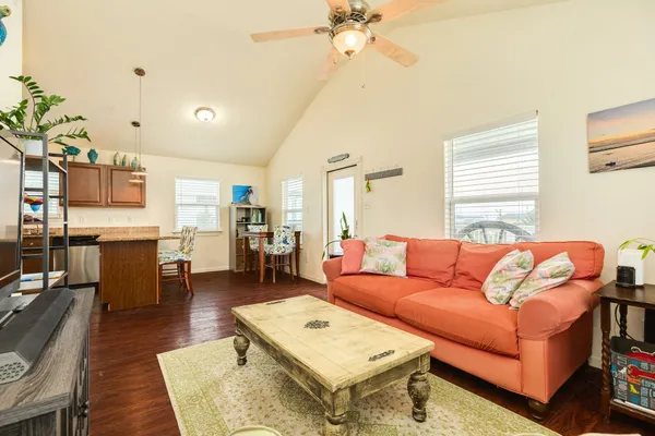 a living room with furniture kitchen view and a window