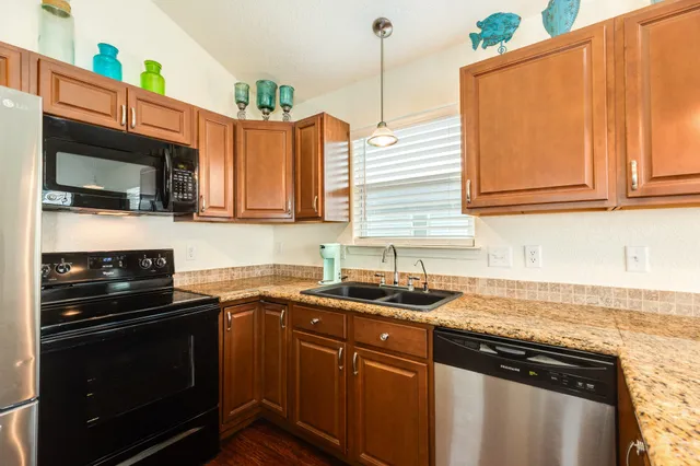 a kitchen with stainless steel appliances granite countertop a sink stove and microwave