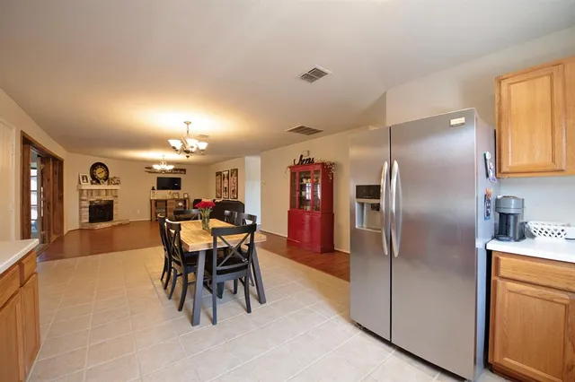 a kitchen with stainless steel appliances granite countertop a stove a sink dishwasher and a refrigerator with wooden floor